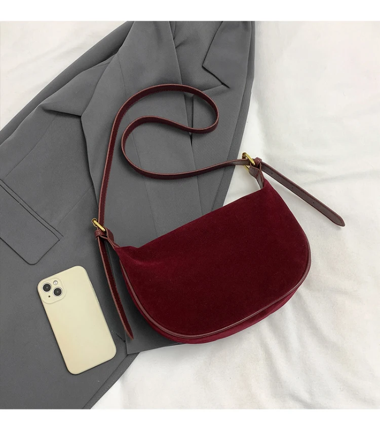 Burgundy suede crossbody bag flat lay with phone