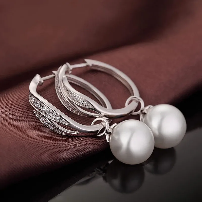 Pearl dangle earrings pair on fabric