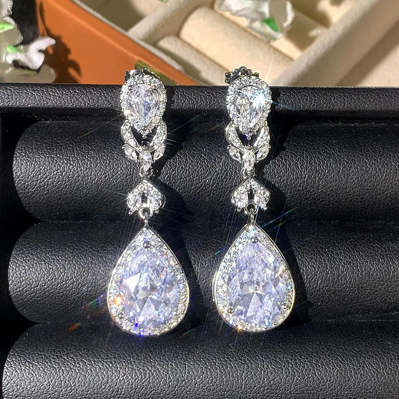Close up of teardrop earrings with halo setting