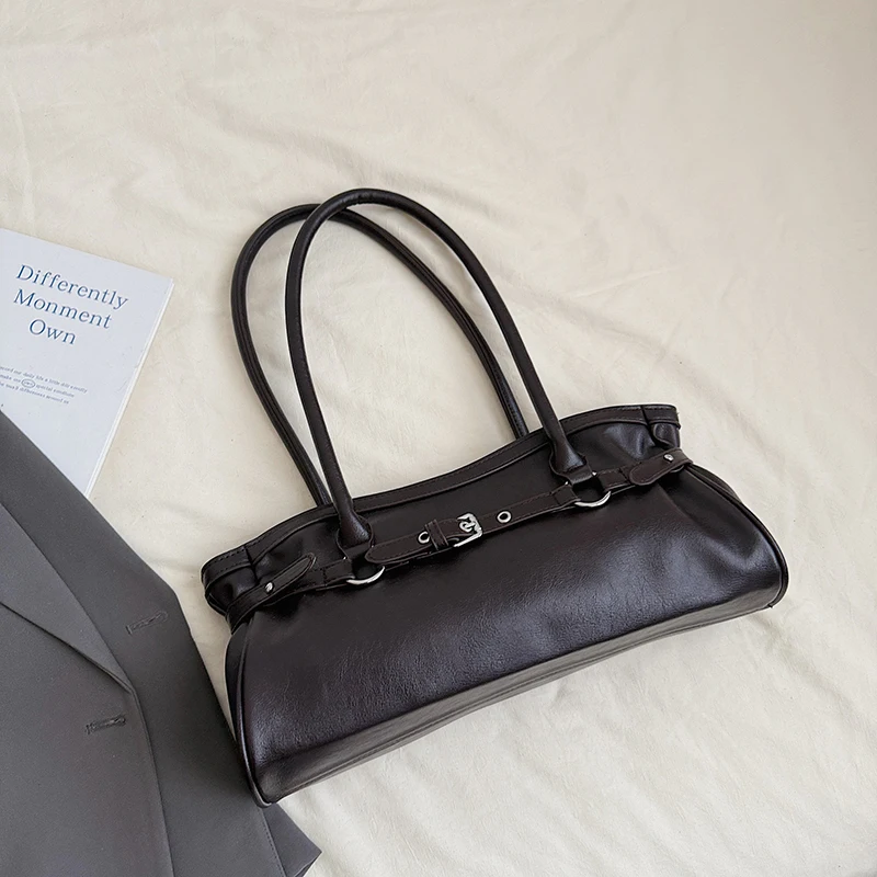 Brown leather tote bag flat lay with rounded handles