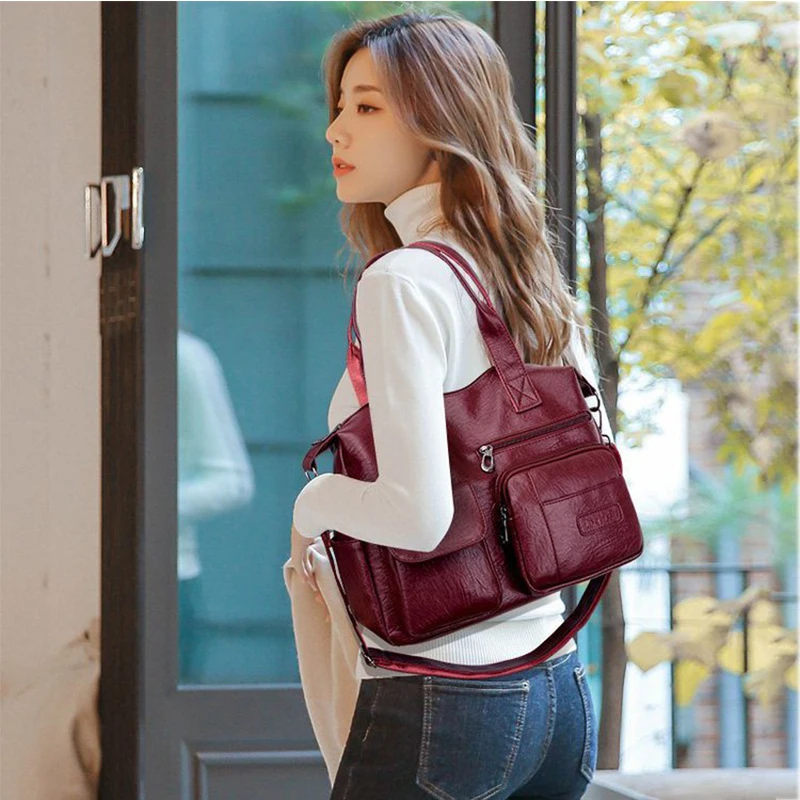 Woman wearing burgundy leather shoulder bag crossbody style